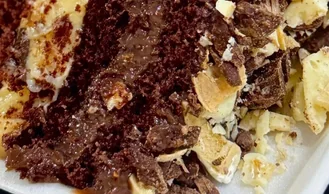 Fatia de bolo de chocolate com creme e pedaços crocantes